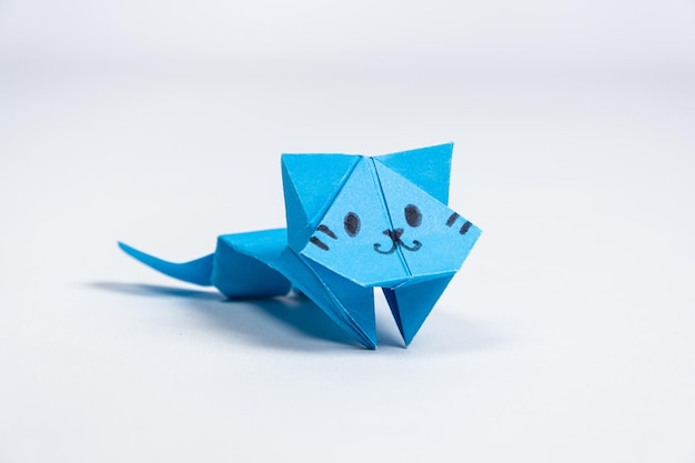 Niebieski papier origami kot rękodzieło dla dzieci i dorosłych DIY figurki zwierząt białe tło