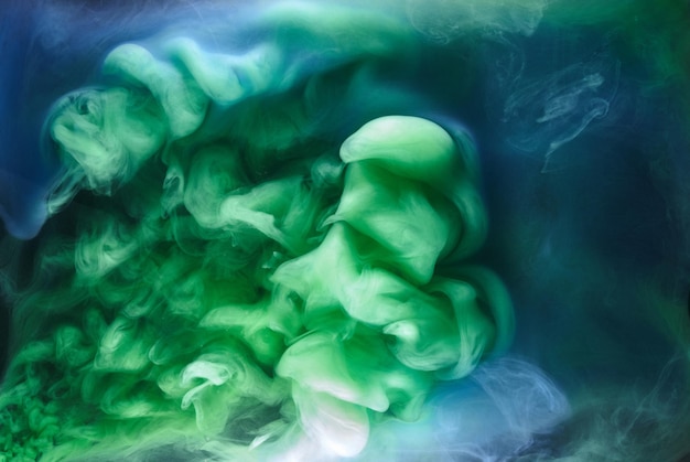 Zdjęcie niebieski zielony dym na czarnym tle, kolorowa mgła, abstrakcyjne wirujące morze oceanu, pigment do farby akrylowej pod wodą