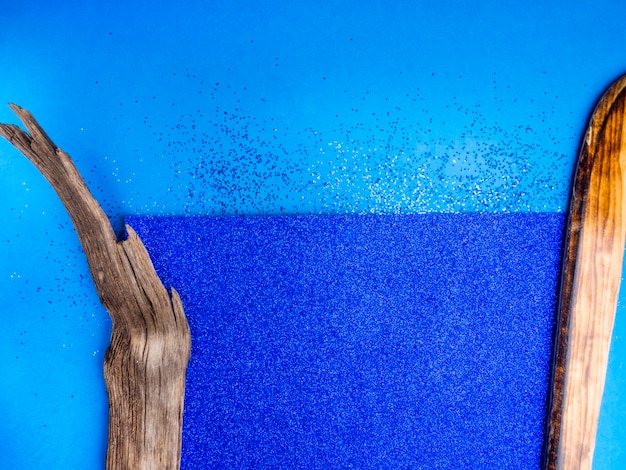 Niebieskie błyszczące tło kartonowe i drewniane elementy dekoracyjne modny kolor roku 2020