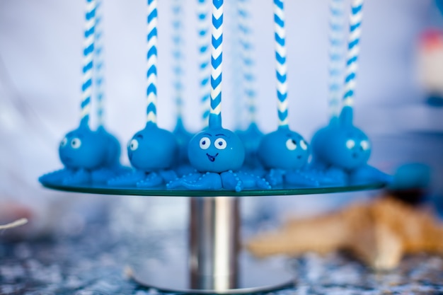 Niebieskie ciasto wyskakuje z zabawnymi ośmiornicami umieszczonymi na szklanym okrągłym talerzu.