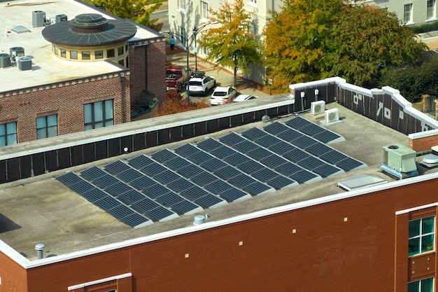 Niebieskie fotowoltaiczne panele słoneczne zamontowane na dachu budynku mieszkalnego do produkcji czystej ekologicznej energii elektrycznej Produkcja koncepcji energii odnawialnej