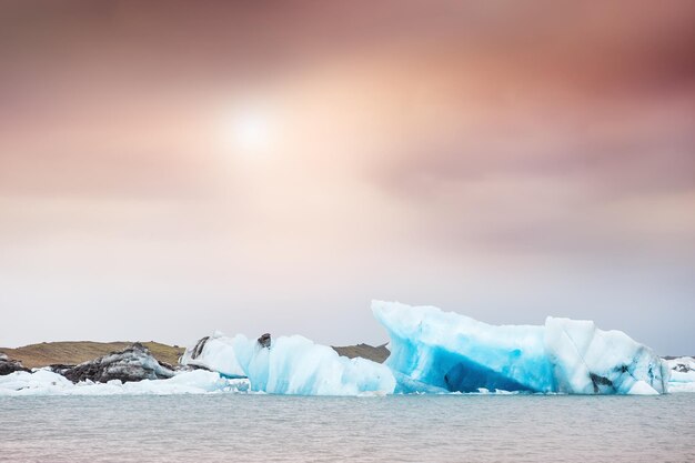 Niebieskie góry lodowe w lagunie lodowcowej Jokulsarlon o zachodzie słońca. Lodowiec Vatnajökull, południowa Islandia