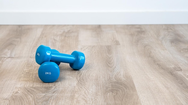 Niebieskie hantle do wykonywania ćwiczeń fitness w domu Koncepcje równowagi życia fitness w stylu życia