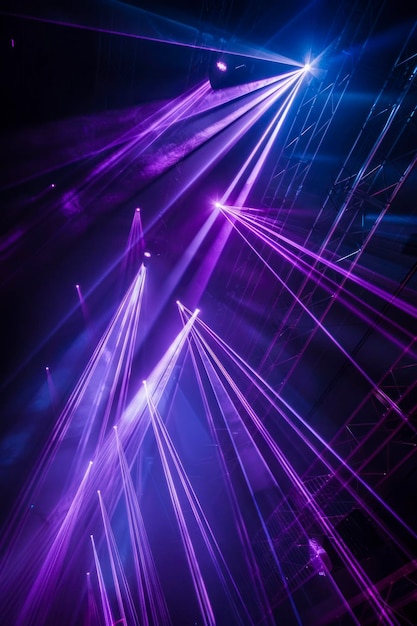 Niebieskie i fioletowe wiązki jasnego światła lasera świecące na czarnym tle