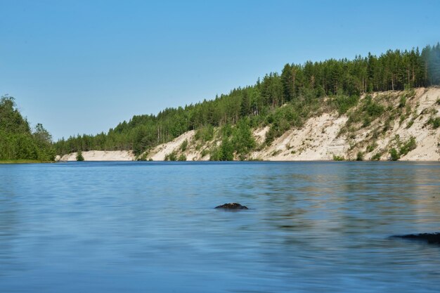 Niebieskie jezioro i zielony las mieszany w słoneczny letni dzień Girvas paleovolcano to popularne miejsce