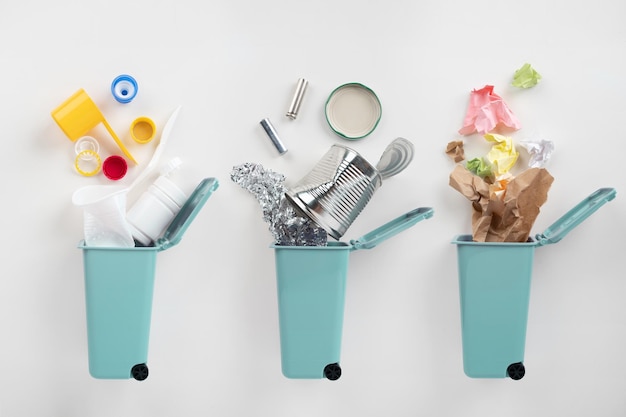 Niebieskie kosze na śmieci i różne śmieci na szarym tle Koncepcja recyklingu