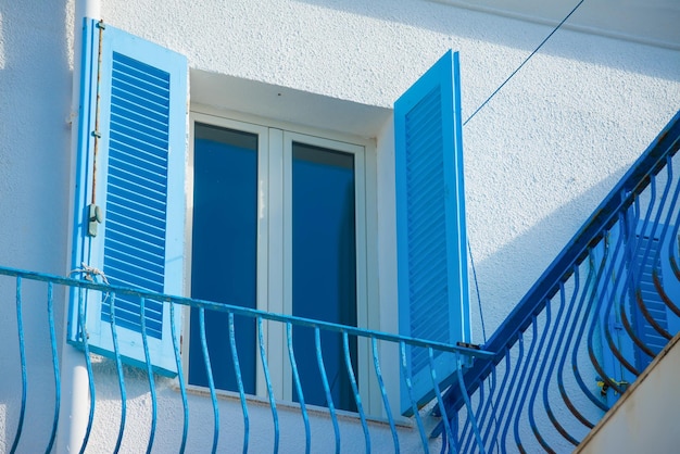 Niebieskie okno i balustrada w białej ścianie