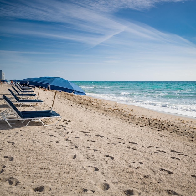 Niebieskie parasole na pustej, piaszczystej plaży nad oceanem Miami Beach Florida Seaside Wczesny poranek