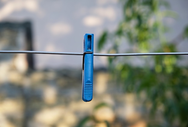 Niebieskie plastikowe clothespin wiszące na metalowym drucie