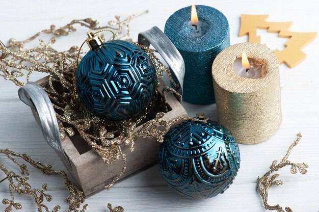 Niebiesko-złote świece zapachowe i świąteczne zabawki na drewnianym rustykalnym