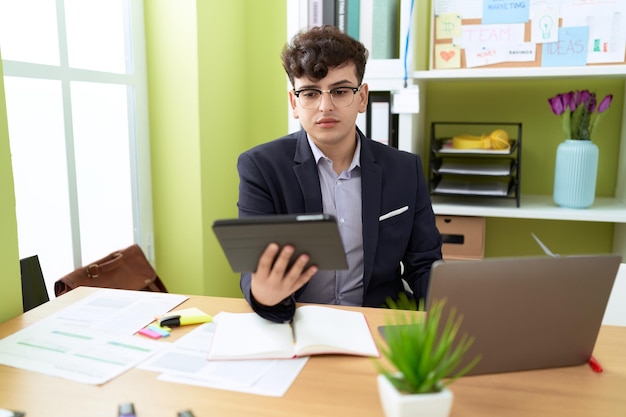 Niebinarny pracownik biznesowy używający touchpad i laptopa w biurze