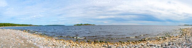 Niebo nad żwirową plażą nad jeziorem.