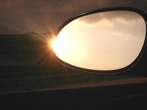 Zdjęcie niebo odbijające się w bocznym lustrze samochodu podczas zachodu słońca