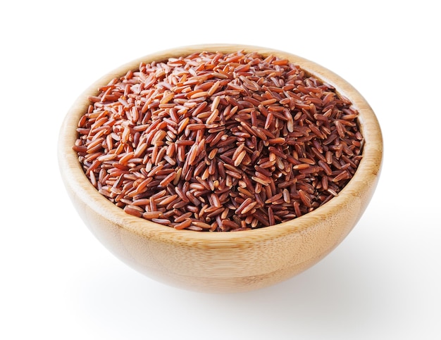 Niegotowany czerwony ryż w drewnianej misce na białym tle ze ścieżką przycinającą