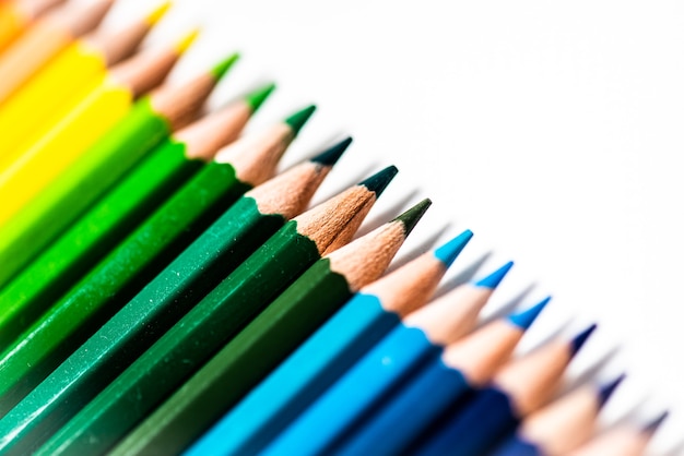 Niektóre różne kolorowe drewniane kredki ołówkowe umieszczone w rzędzie przed białym tle na białym tle