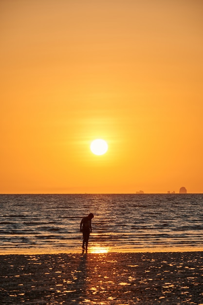 Zdjęcie niektórzy ludzie są na plaży podczas zachodu słońca