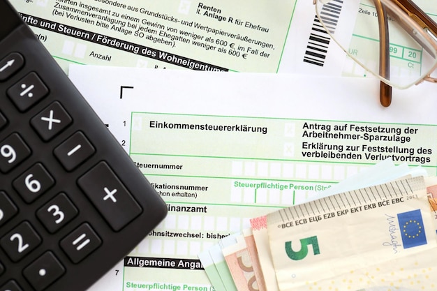 Niemiecki formularz zwrotu podatku dochodowego z europejskimi rachunkami i kalkulatorem leży na stole księgowym z bliska Pojęcie okresu rozliczeniowego w Niemczech
