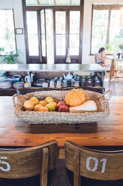 Nieociosany kosz z baniami i owoc na drewnianym stole