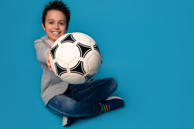 Nieostrość na piłce nożnej w rękach cute uśmiechnięta nastolatka.