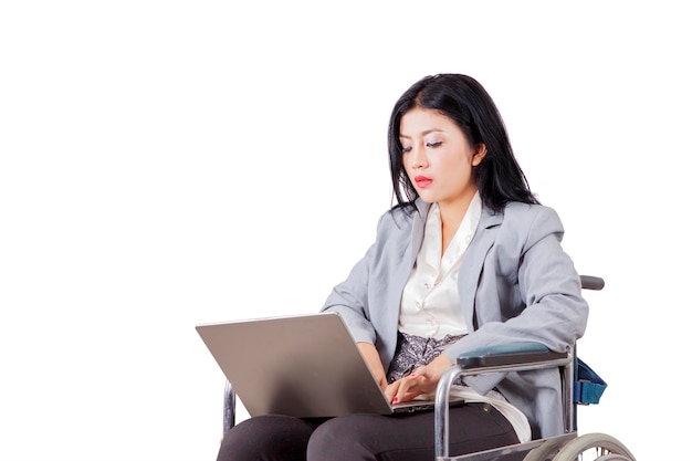 Niepełnosprawna bizneswoman używa laptop na studiu