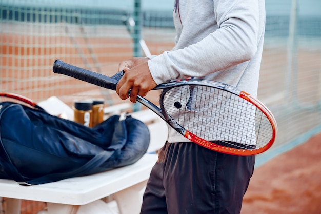 Nierozpoznany tenisista naprawia pokrycie trzonka rakiety tenisowej