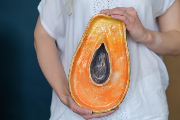 Nierozpoznawalna ceramika trzymająca miskę w kształcie papai