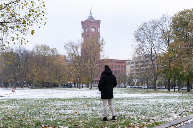 Nierozpoznawalny młody turysta patrzący na Rotes Rathaus i zaśnieżoną okolicę