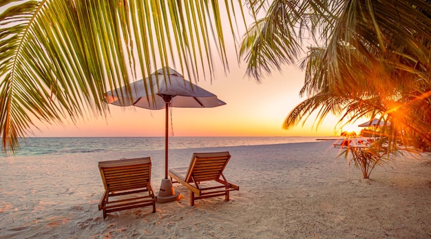 Niesamowite wakacje na plaży Krzesła liście palm zachód słońca plaża blisko morza Letnie romantyczne wakacje dla par