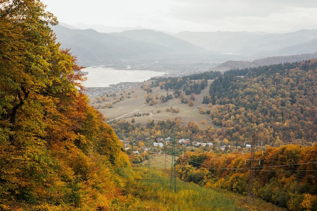 Niesamowity widok na góry w jesienny dzień z żółtymi modrzewiami i dolinę z górą jeziora.