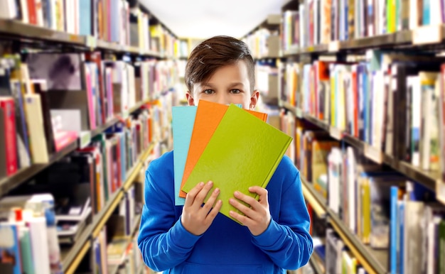 nieśmiały uczeń ukrywający się za książkami w bibliotece