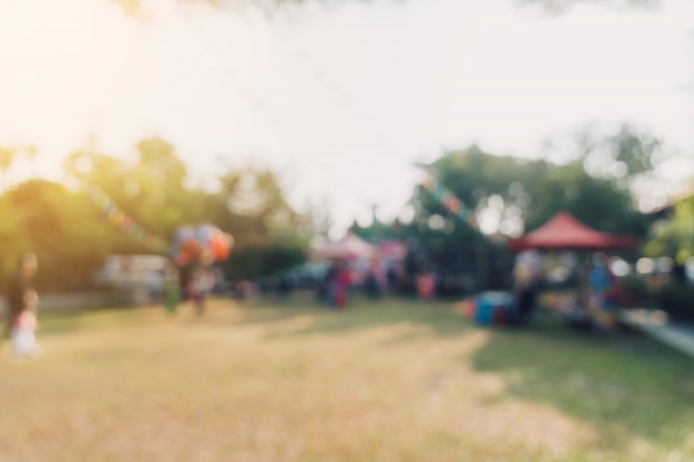 niewyraźne ludzi i światło słoneczne na festiwalu w ogrodzie parku miejskiego