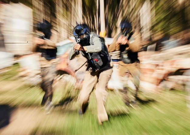 Zdjęcie niewyraźne wojsko i ludzie z bronią do treningu paintballowego i gry akcji w przyrodzie rozmyci fitness i żołnierze strzelający do wojny na polu bitwy, aktywność fizyczna lub cardio w lesie