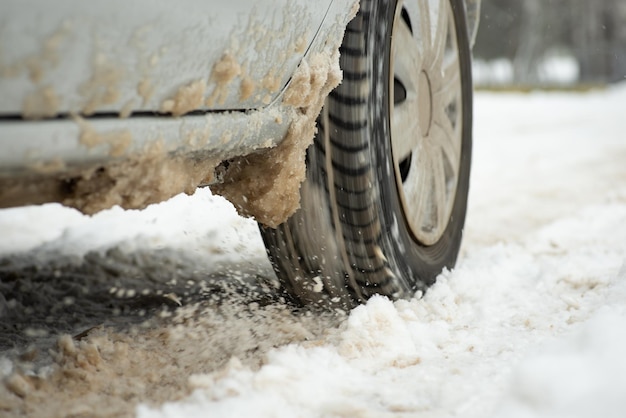 Niewyraźne zdjęcie koła samochodu podczas jazdy po zaśnieżonej drodze Zła pogoda niebezpieczna zimowa jazda