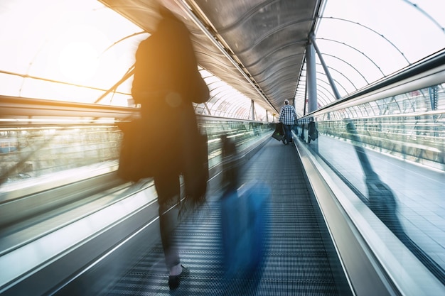 Niewyraźni Pasażerowie Pędzący W Ruchu Na Skywalk Na Nowoczesnym Lotnisku. Idealny Do Układów Stron Internetowych I Czasopism