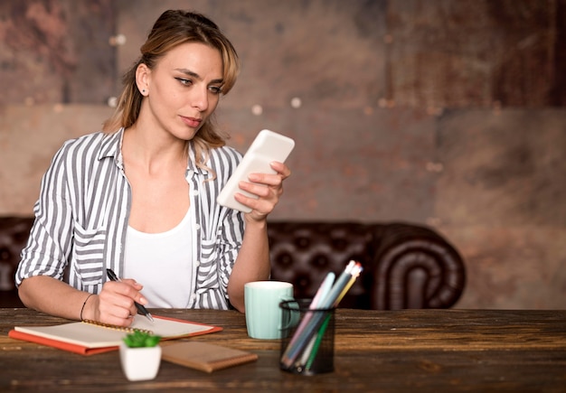 Zdjęcie niezależna kobieta weryfikująca telefon komórkowy