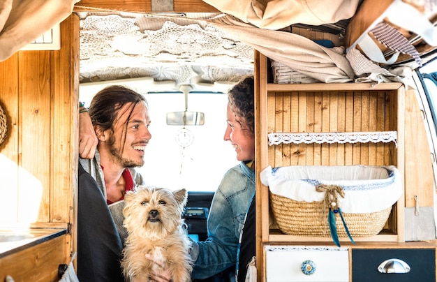 Niezależna para z małym psem podróżująca razem oldtimerowym mini vanem