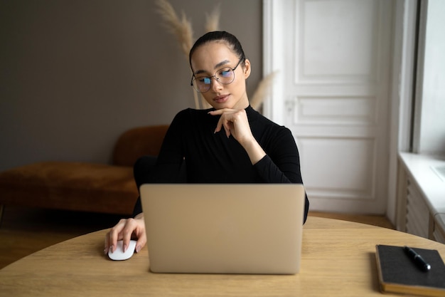 Niezależny projektant kobieta w okularach pracuje w biurze używa laptopa