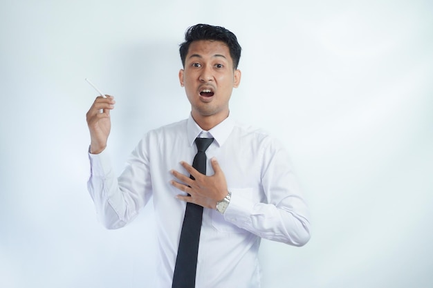 Zdjęcie niezdrowy młody azjatycki biznesmen dostał bólu w klatce piersiowej podczas palenia odizolowanego na białym tle