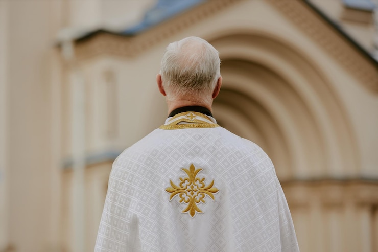 Zdjęcie nieznany ksiądz stojący na zewnątrz.