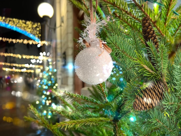 Night City Christmas ball na gałęzi drzewa sosnowego i oświetlenie w średniowiecznym Tallinnie Stare Miasto