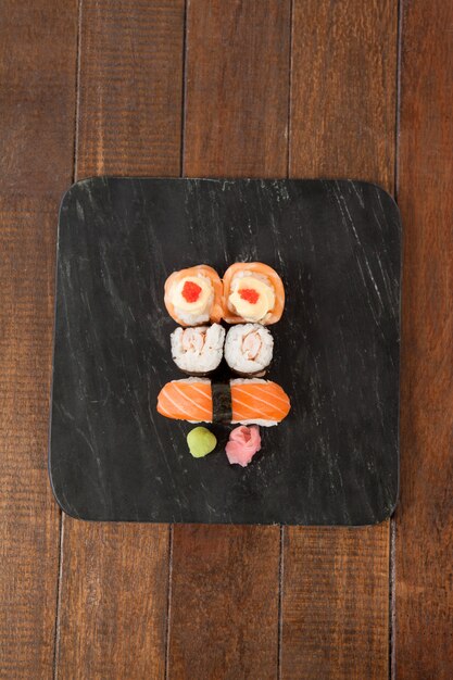 Nigiri i uramaki sushi serwowane na czarnym kamiennym łupku