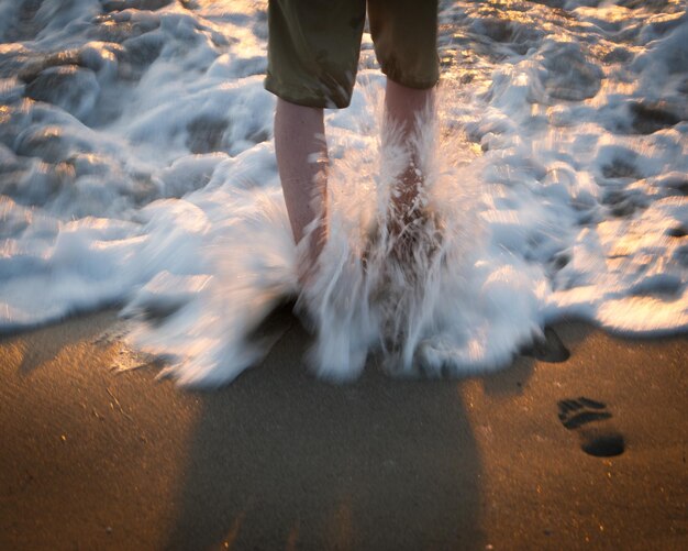 Zdjęcie niska część człowieka stojącego na plaży