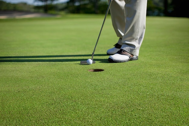 Zdjęcie niska część człowieka stojącego na polu golfowym