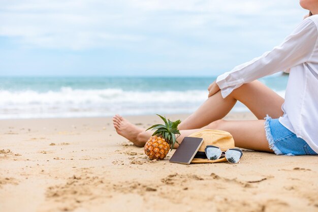 Niska część kobiety relaksującej się na piasku na plaży na tle nieba