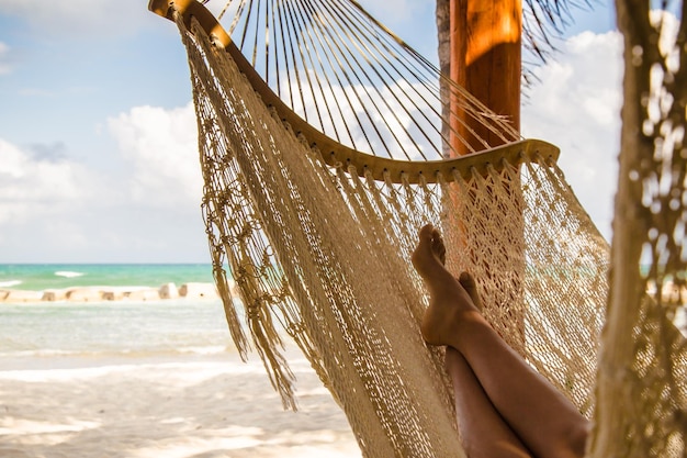 Niska część kobiety w hamaku na plaży na tle nieba