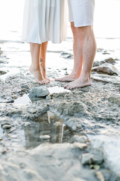 Zdjęcie niska część pary stojącej na plaży