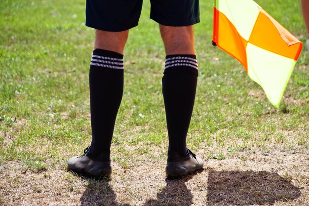 Zdjęcie niska część piłkarza z flagą stojącą na boisku