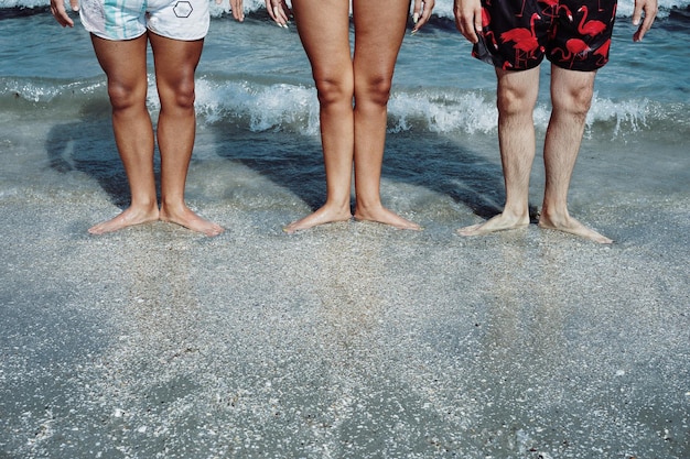 Zdjęcie niska część przyjaciół stojących na brzegu