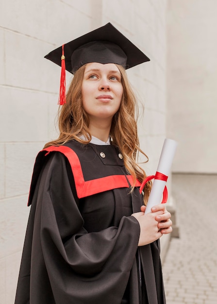 Zdjęcie niski kąt dziewczyna z dyplomem