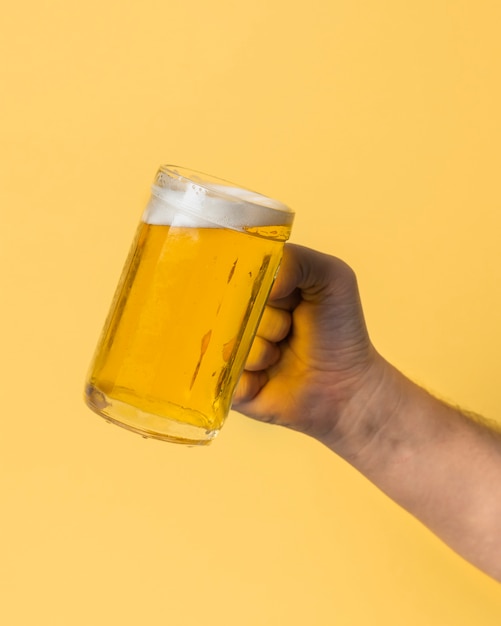 Zdjęcie niski kąt ręki trzymającej kufel piwa
